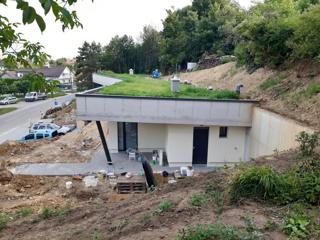 Casa interrata in costruzione a Trencin, tetto verde con tubi di sfiato e terrazza piena di materiali