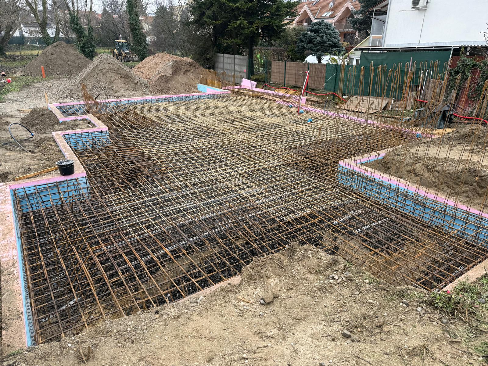 Foundation slab of an earth-sheltered house in Bratislava, rebar and insulation panels laid before concrete pour