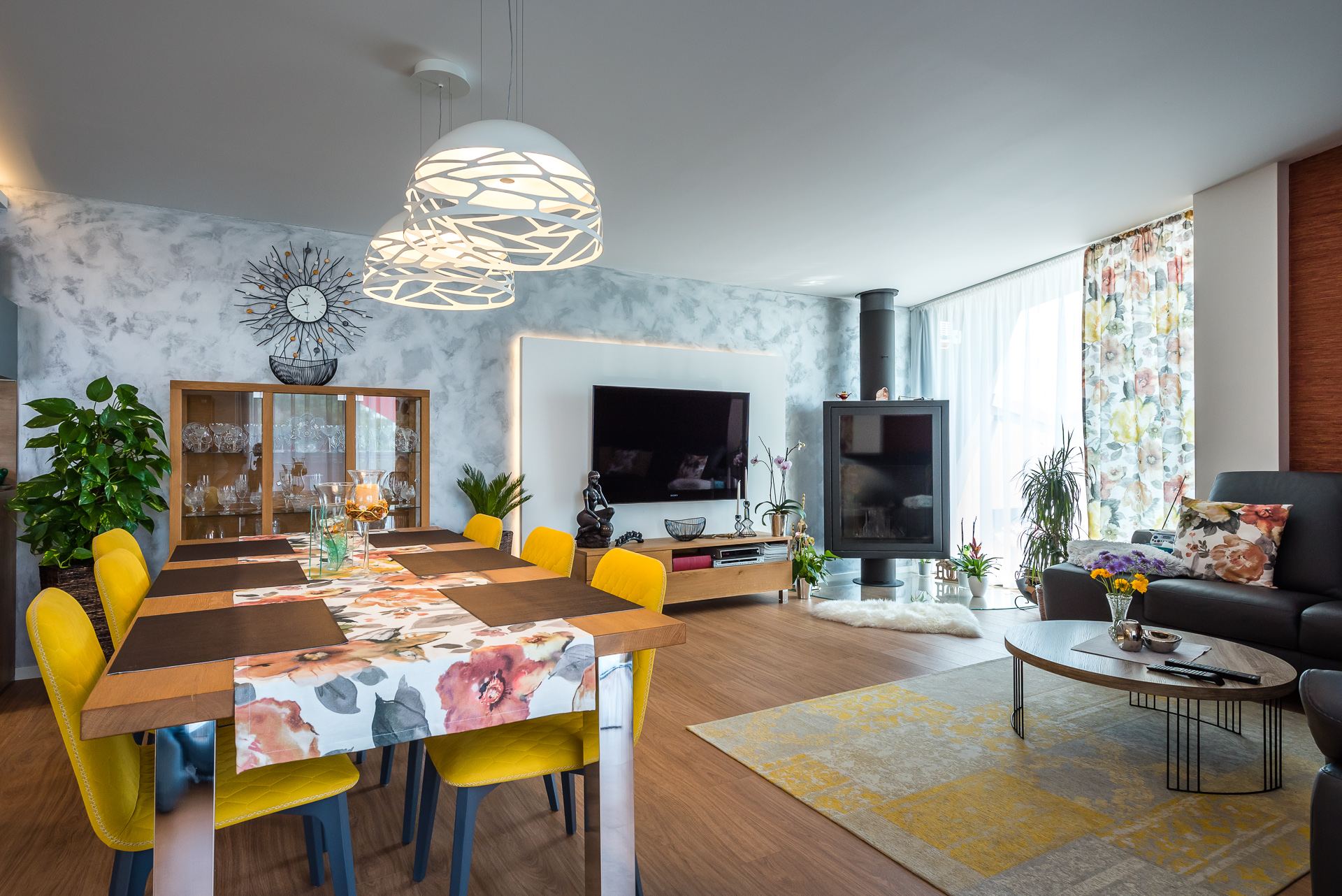 Living-dining room of the Hoblina earth-sheltered house in Kosice, with a wood stove, TV and glazed wall
