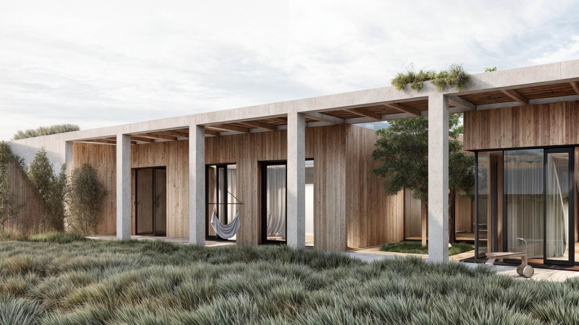 Earth-sheltered house Devin behind tall grass, wood-clad facade, concrete columns and terrace with hammock and tree