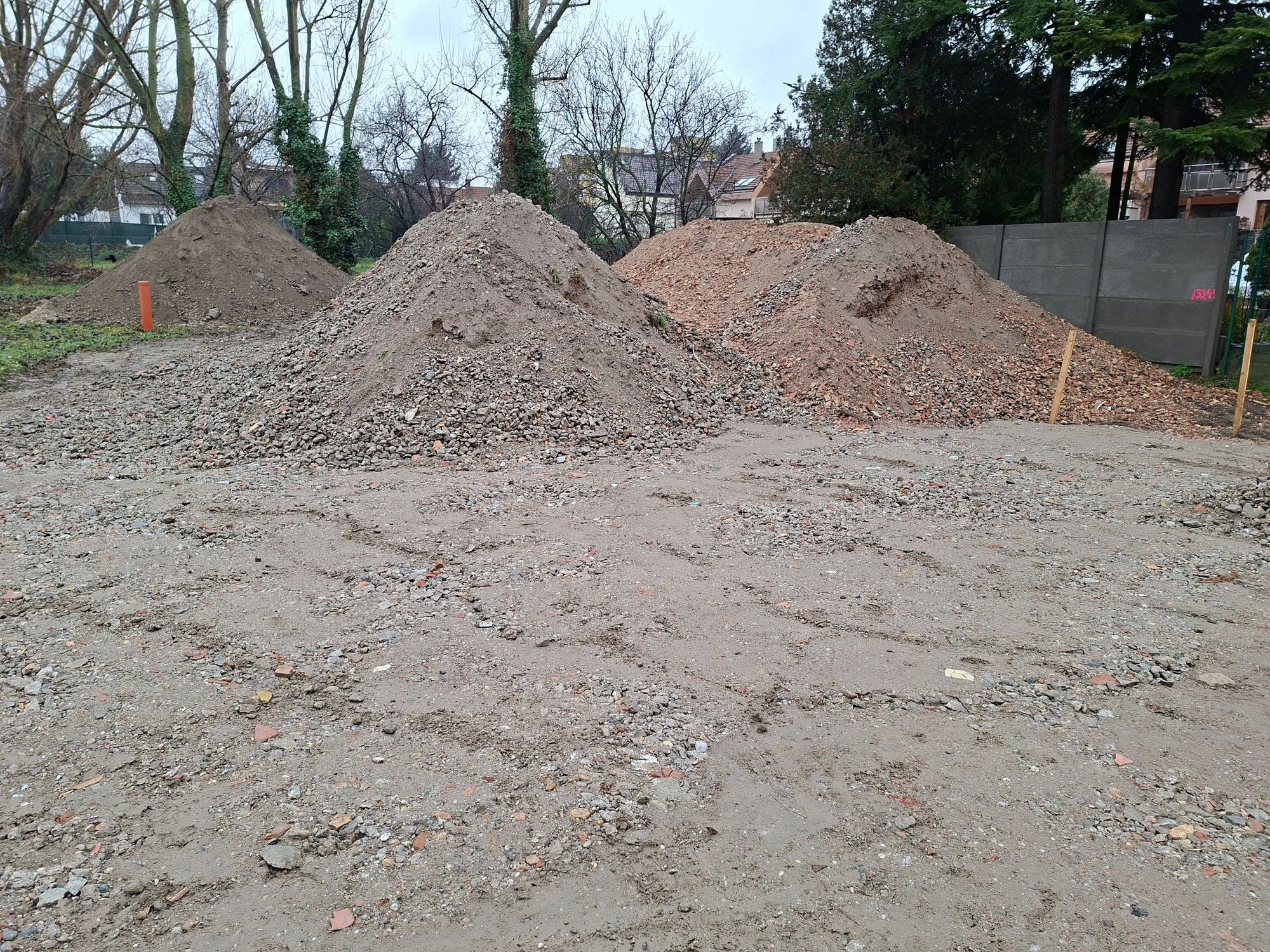 Construction site in Bratislava with mounds of excavated soil and brick rubble, before building this earth-sheltered house