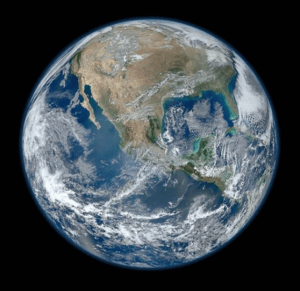 Satelitný pohľad na Zem so Severnou Amerikou, oblakmi nad oceánom a tenkou žiarou atmosféry na okraji planéty.