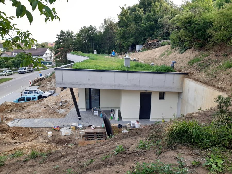 Casa interrata in costruzione a Trencin, tetto verde con tubi di sfiato e terrazza piena di materiali