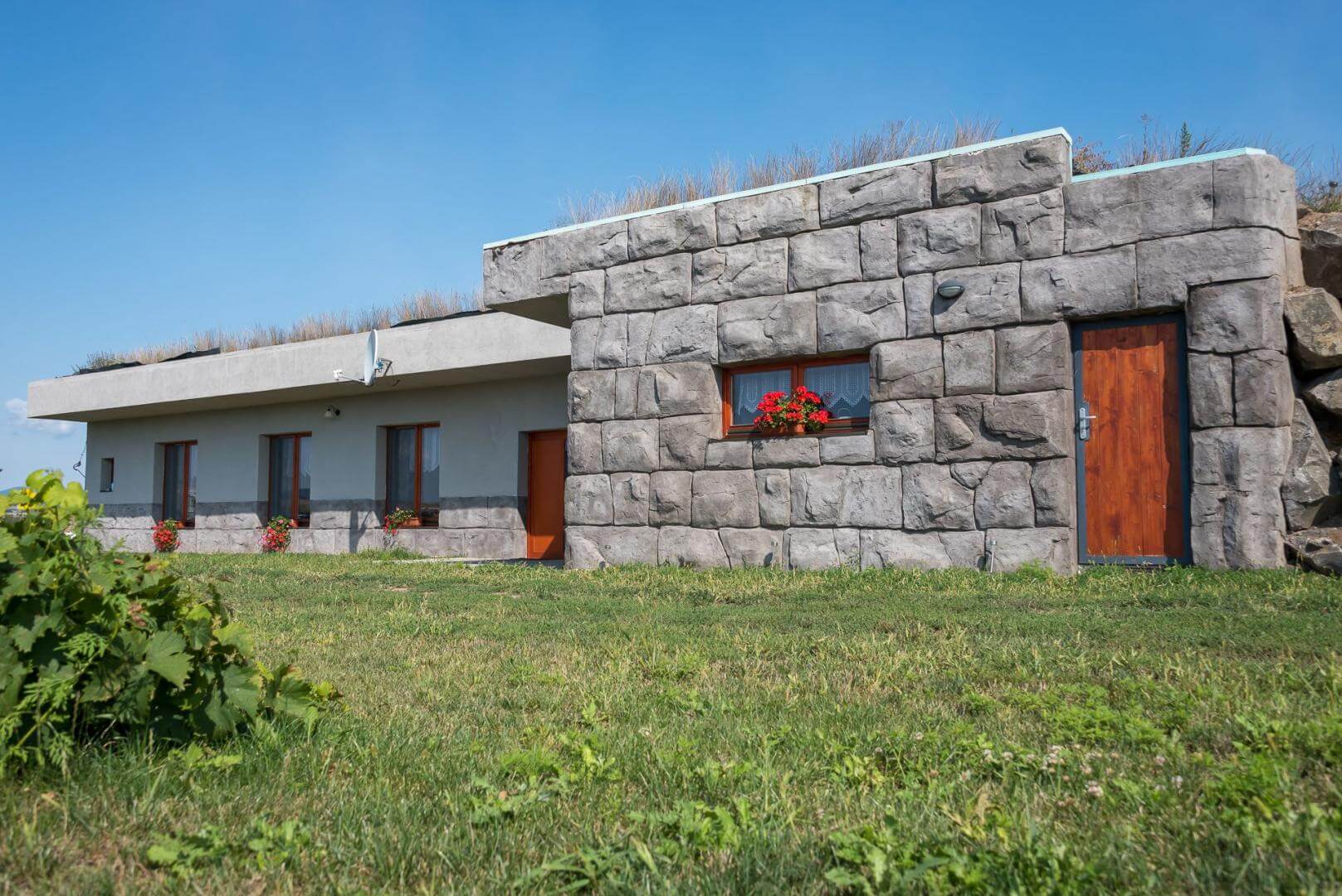 A house covered with soil on a flat plot